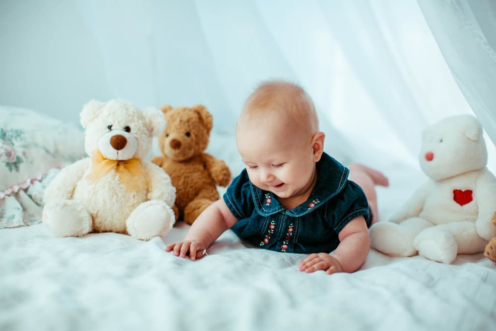 bebè con peluche