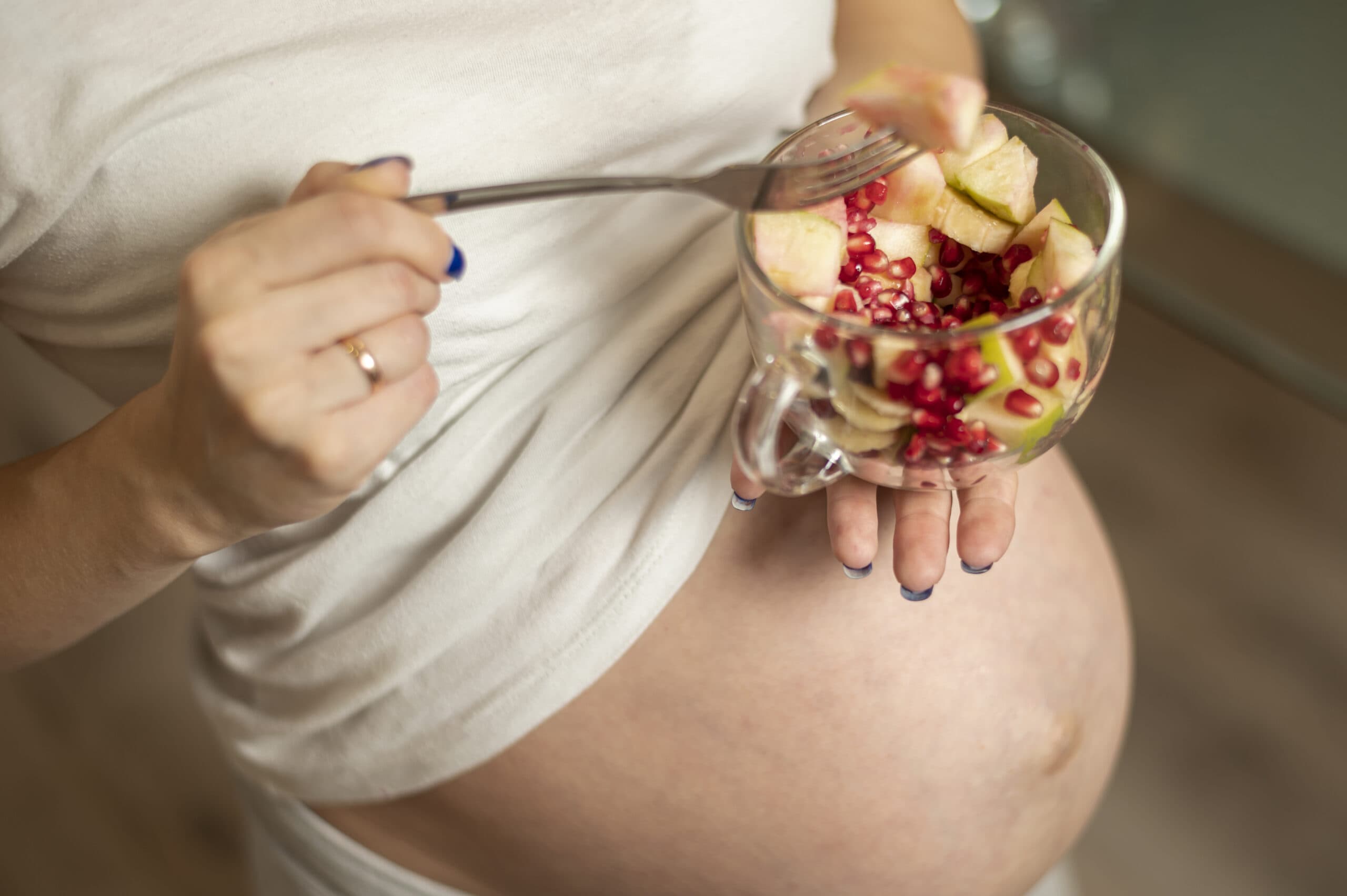 donna incinta che mangia frutta