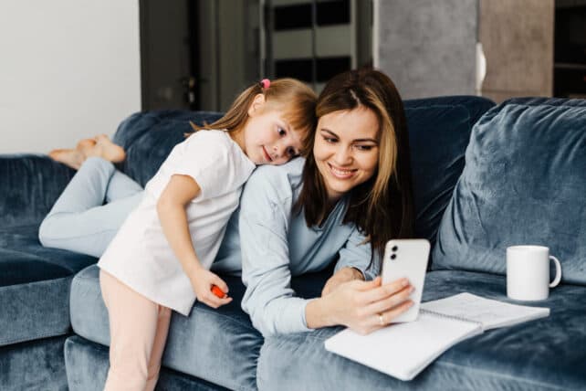 mamma e bambina sul divano con smartphone