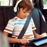 bambino che ascolta musica in auto con cuffie