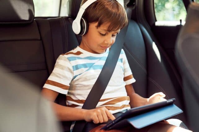 bambino che ascolta musica in auto con cuffie