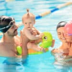 bambini e genitori che giocano insieme in piscina