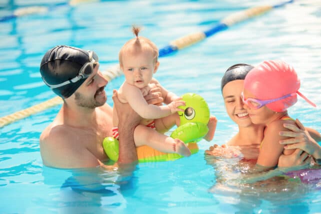 bambini e genitori che giocano insieme in piscina