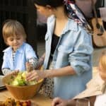 Bambino a tavola che si serve insalata