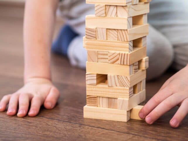 bambino che gioca con costruzioni in legno