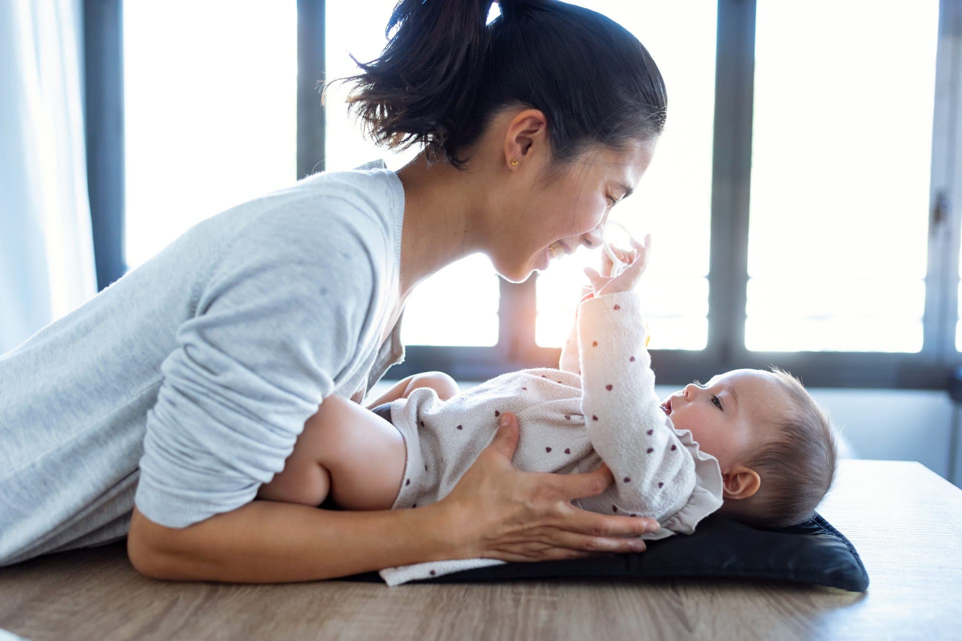 mamma che cambia bambino sul fasciatoio