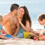 bambini che giocano in spiaggia con genitori