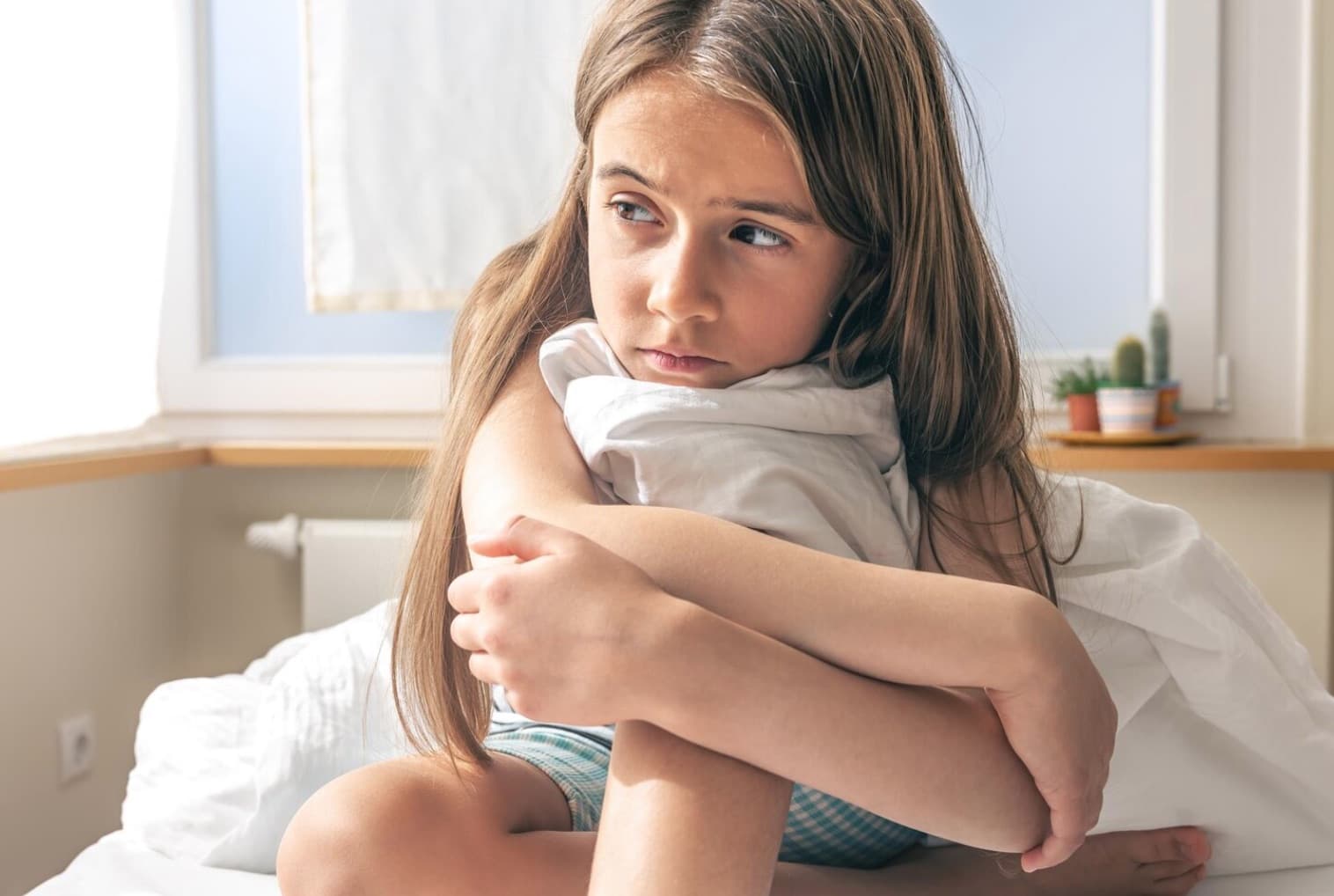 bambina seduta sul letto