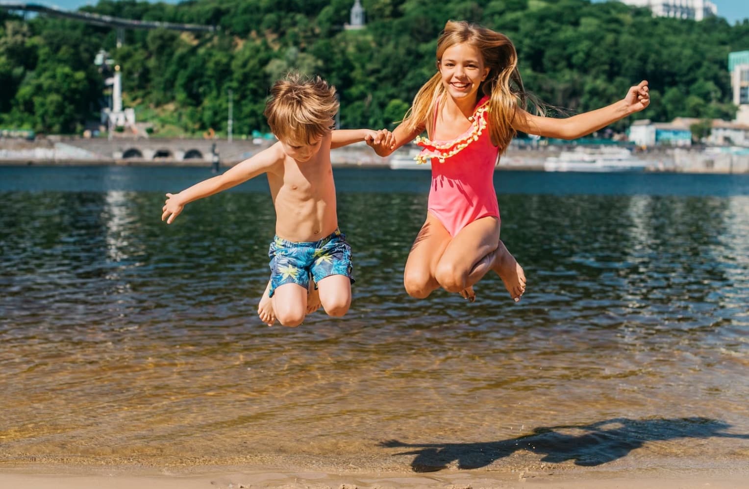 bambini che saltano felici in riva al mare