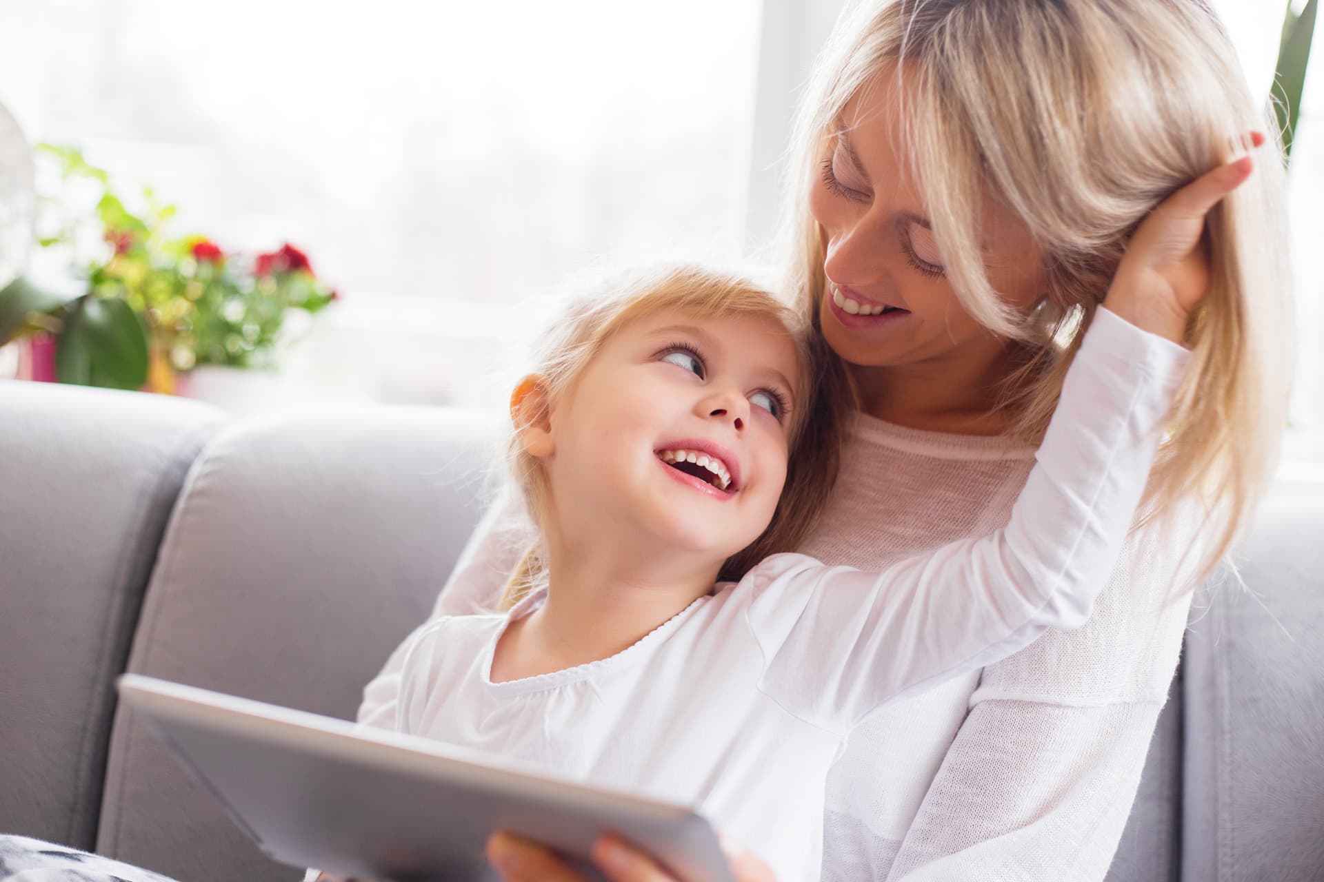 mamma in braccio alla mamma che guardano insieme su iPad