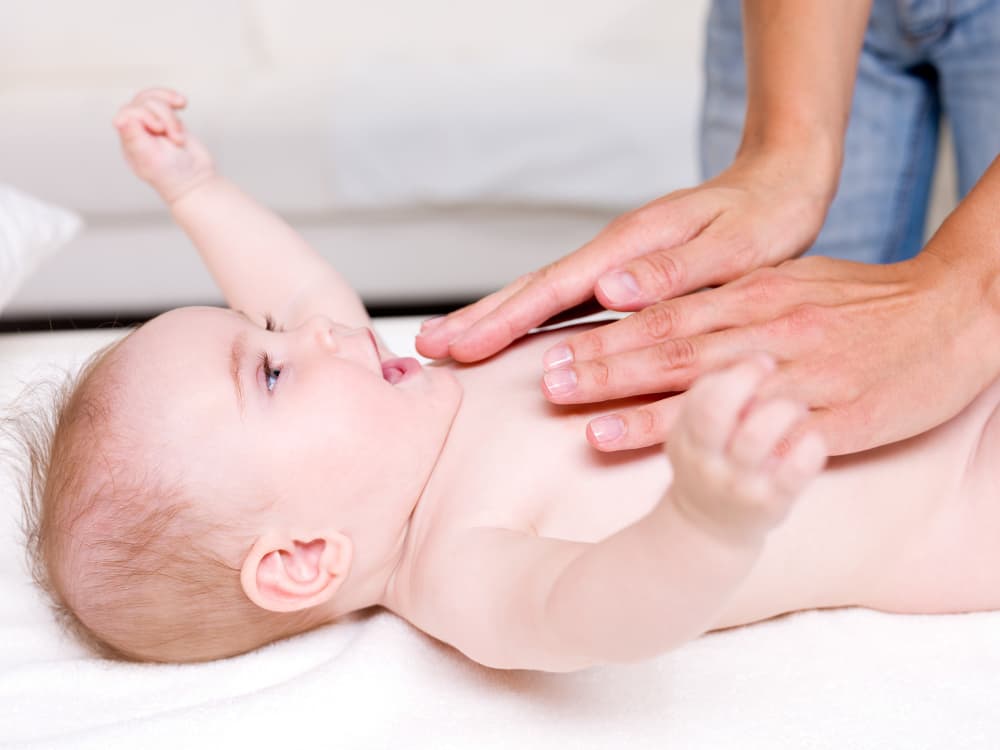 mamma che massaggia il neonato