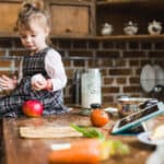 bambina seduta su tavolo di cucina