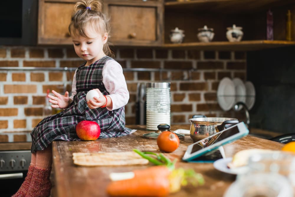 bambina seduta su tavolo di cucina