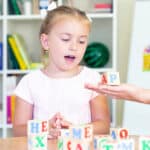 bambina che gioca con cubi di lettere