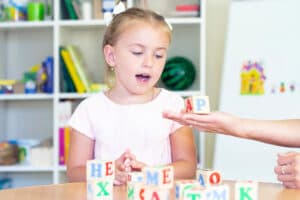 bambina che gioca con cubi di lettere