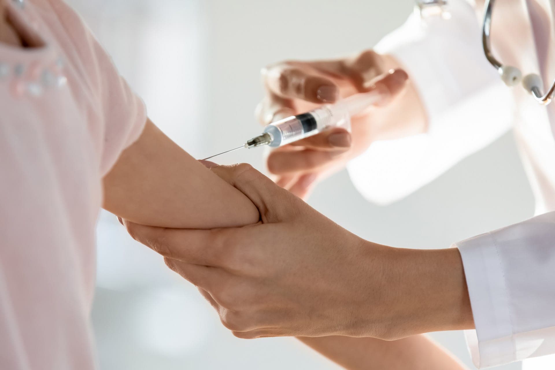 medico che vaccina un adulto