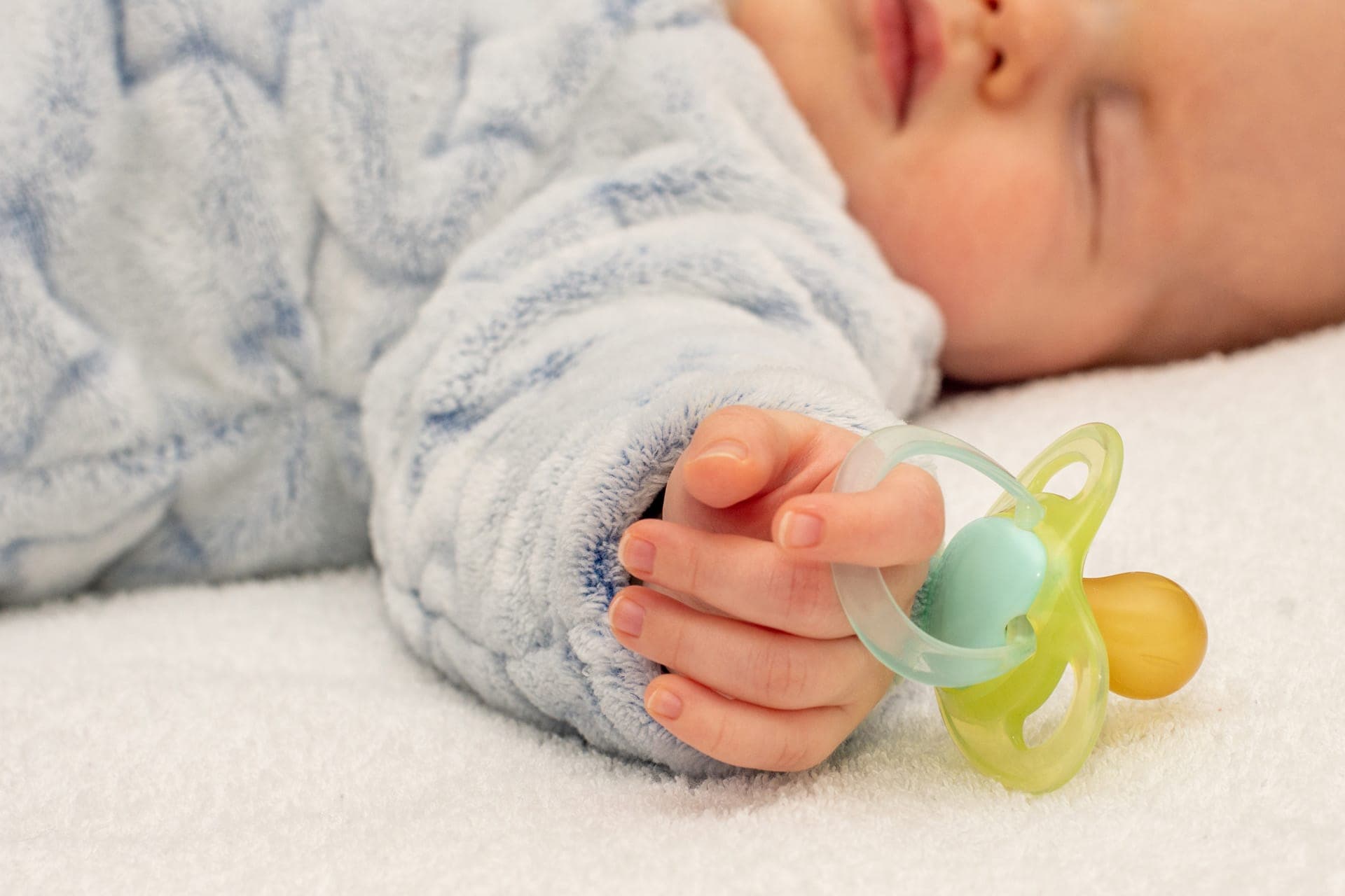 bambino che dorme con succhietto in mano