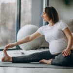 donna incinta che pratica yoga